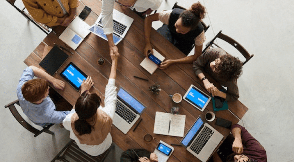 People sitting behind a table holding a meeting